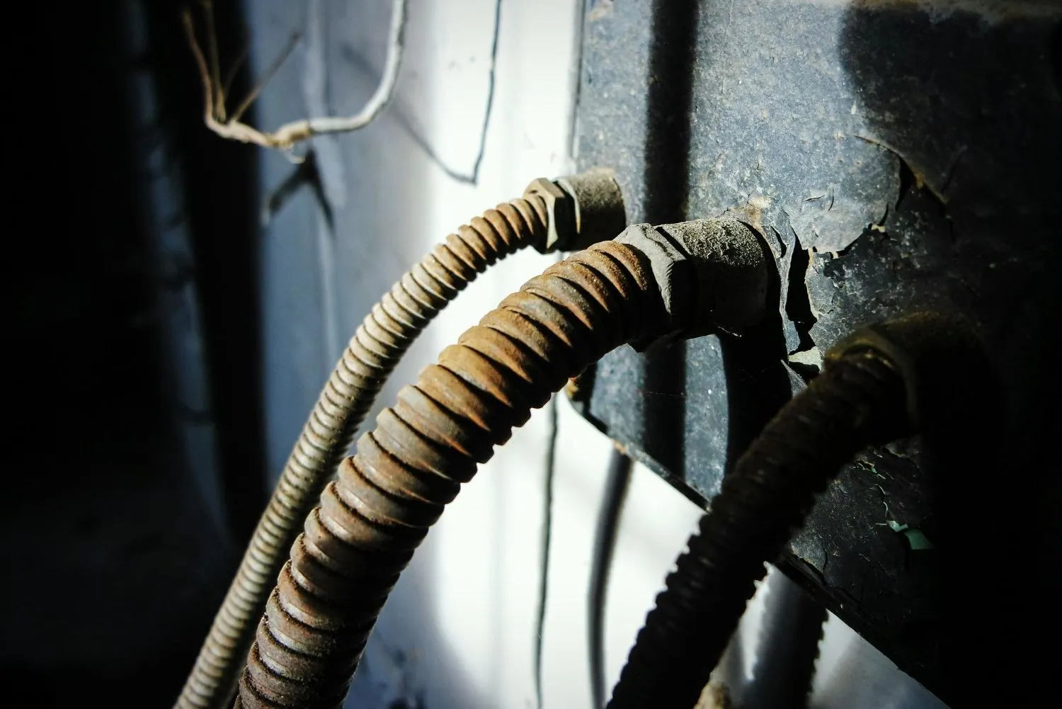 Close-up of worn flexible conduit running to a garage door opener